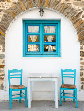 view to traditional greek taverna with two chairs