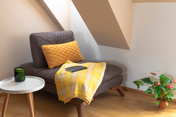 Comfortable cozy corner for reading concept. Chair with blanket, coffee table