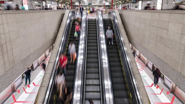 4K Time-lapse of Asian people walking and using escalator at MRT subway underground station in Singapore. Public transportation, Asia everyday city life, or commuter urban lifestyle concept. Tilt up