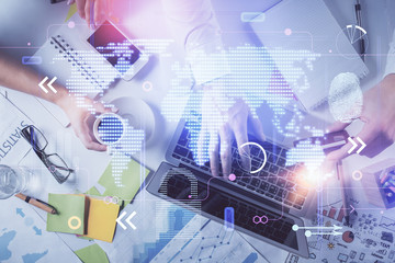 Multi exposure of man's hands typing over computer keyboard and world map hologram drawing. Top view. Technology concept.