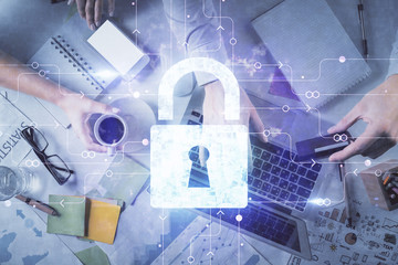 Double exposure of man and woman working together and lock hologram drawing. Security concept. Computer background. Top View.