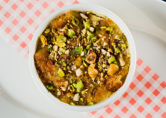 Turkish dessert kunefe, kunafa, kadayif with pistachio powder and cheese, served hot, very sweet. Turkish traditional dessert.