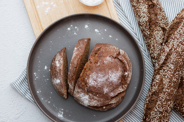 Black bread on a light background with space for text . Homemade fresh pastries. Bread with seeds.