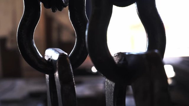 Big hook of tower crane holds metal chain 