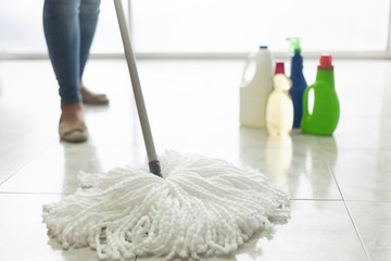 person mopping the floor with cleaning