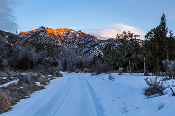 Last light on orange cliffs above snowed in trail into Utah desert wilderness. © DCrane Photography