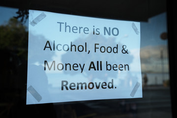 There is no alcohol, food and money all have been removed warning sign in a bar and restaurant window closed during the coronavirus covid-19 pandemic lockdown.