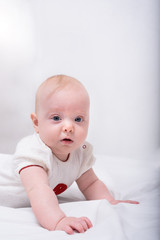 Portrait of cute little baby lying down on bed. 3 months baby Vertical frame