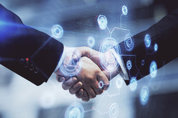 Double exposure of data theme hologram and handshake of two men. Partnership in IT industry concept.