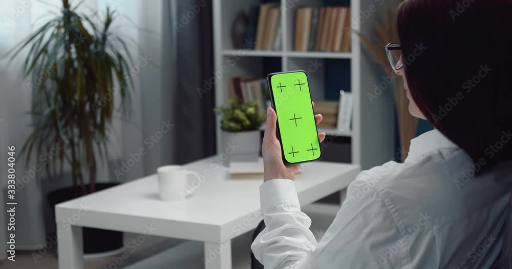 Poster young lady in casual outfit sitting on comfortable couch and using mobile with empty screen. space f