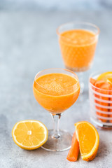 Freshly Made Organic Carrot-Orange Juice on grey background, vertical format. Selective focus