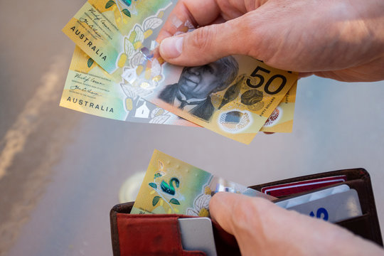 Hands holding wallet with australian dollars and make a payment - coronavirus finance struggle concept