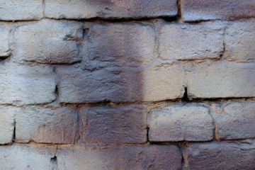 brick wall with abstract strokes of brown-gold paint, close-up