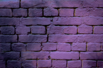 background of a brick wall painted with purple spray paint