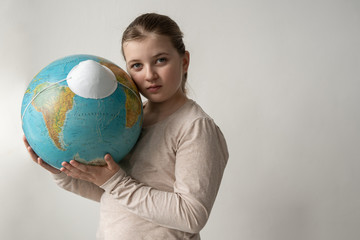 girl holding worl model globe with face virus protection mask respirator agains white background 