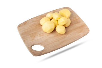  peeled potatoes lies on a kitchen wooden cutting board. isolate on white background