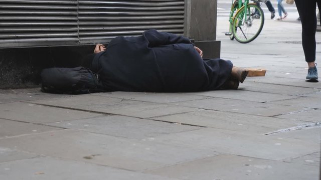 A homeless person sleeping on a street.