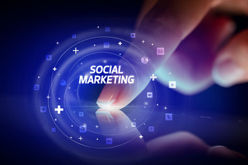 Finger touching tablet with social media icons and SOCIAL MARKETING
