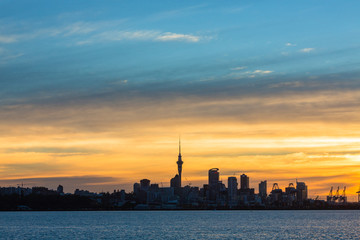 Obraz na płótnie Canvas ニュージーランド　オークランドの桟橋からの夕焼けで染まった空とスカイタワー