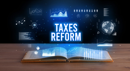 TAXES REFORM inscription coming out from an open book, creative business concept