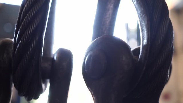 Big hook of tower crane holds metal chain 