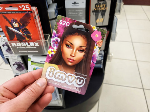 IMVU gift card in a hand over gift cards background.