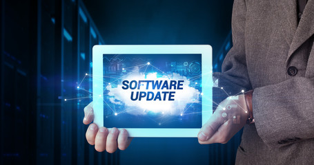 Young business person working on tablet and shows the inscription: SOFTWARE UPDATE