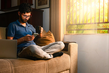 Obraz premium Latin receiving message at his home. Work at home concept.
