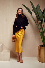 Fashion model brunette hair wear yellow silk dress skirt black top sandals high heels accessory bag...