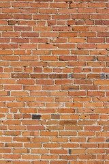 Shabby chic old brick wall texture background with deteriorating bricks in colors of red and orange