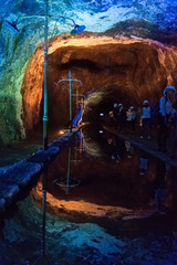 Interior of a salt mine: mirror of water and walls illuminated with color lights