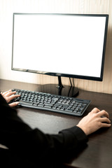 Remote work during quarantine. The girl works at the computer, on the monitor a white screen for the layout. Vertical frame