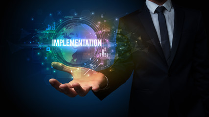 Elegant hand holding IMPLEMENTATION inscription, digital technology concept