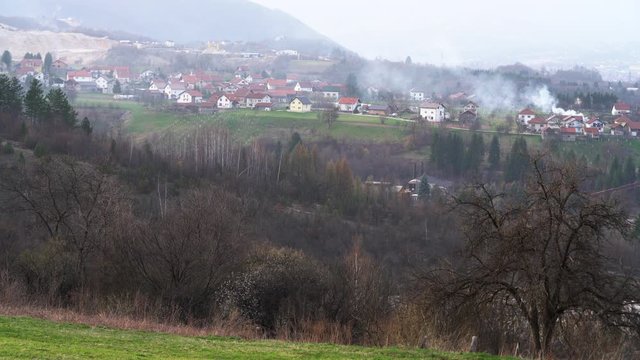 Landscape of Village in spring with moving smoke over houses, burning trash - (4K)