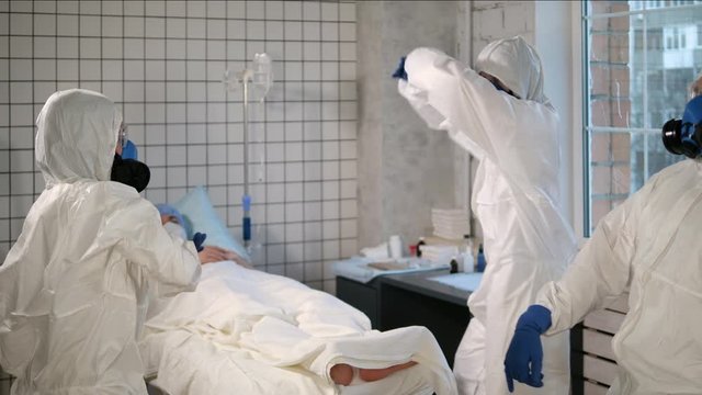 Team of Doctors in protective suits dancing in the hospital chamber.