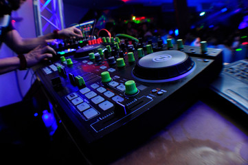 Fototapeta na wymiar Manos de DJ y consola de sonido en discoteca