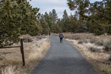Obraz premium Woman walking while social distancing in nature preserve