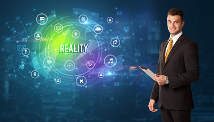 Businessman thinking in front of technology related icons and REALITY inscription, modern technology concept