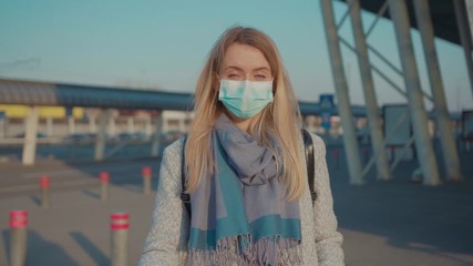 Woman wearing Protective Face Mask to avoid disease COVID-19 coronavirus infection look at camera near airport pandemic disease virus tourist epidemic air health illness slow motion