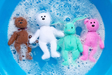 Soak rabbit dolls with  bear toys in laundry detergent water dissolution before washing.  Laundry...