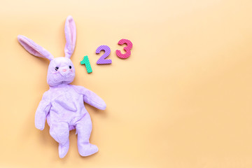 Rabbit toy with  numerals on yellow background. Education concept.