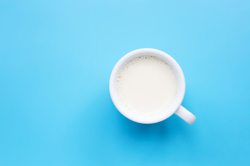 Cup of milk on blue background.