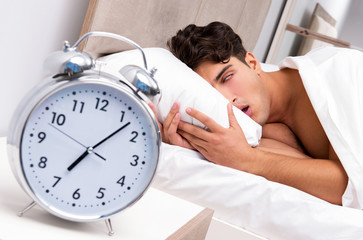 Young man having trouble waking up in the morning