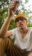 man with mustache and hat showing a talisman in nature