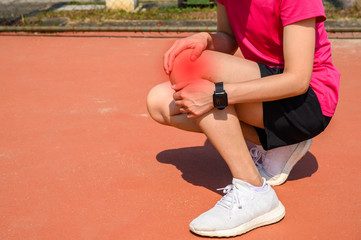 Cropped shot of woman runner suffering from Iliotibial Band Syndrome (ITB). It cause from overuse...