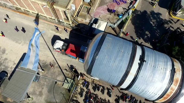 Aerial scene with drones. Aerial camera showing the flag of Argentina and tracking truck with tank. Buenos Aires, Argentina..