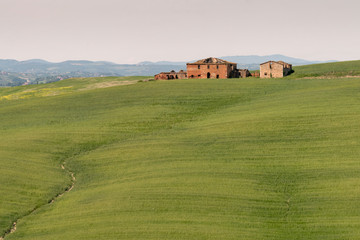 Obraz premium Abandoned villa sitting on top of a hill in Tuscany, Italy.