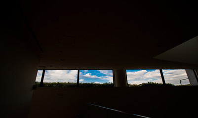 The blue sky and white clouds when looking through the window from a dark room