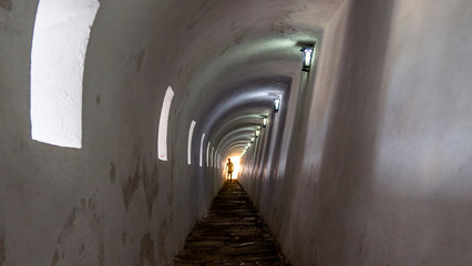 Obraz premium Unrecognizable man`s silhouette walking through a tunnel.