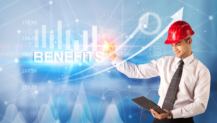 Young businessman with helmet drawing BENEFITS inscription, modern business technology concept